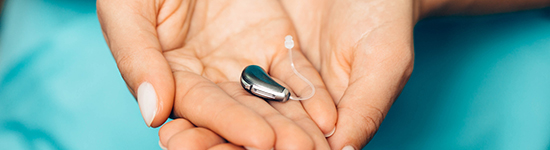 Hearing aid in cupped hands